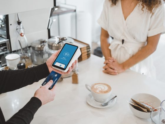 Barista putting Credit Card with a chip into a phone to pay.