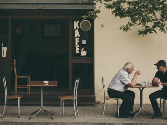 Two men sitting at a table outside of a cafe in Durrës, Albania