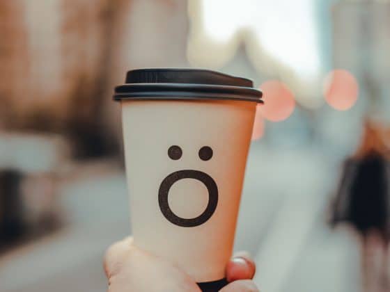 "to go" coffee cup with a hello face emoji